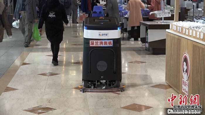 商场内正在进行消毒作业的消毒洗地机器人。　杨予頔 摄